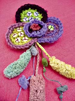 Bracciali e spilla a crochet con perline e paillettes