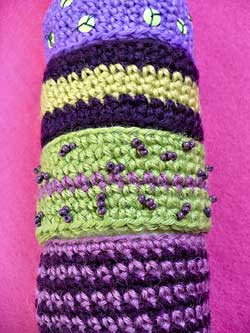 Bracciali e spilla a crochet con perline e paillettes