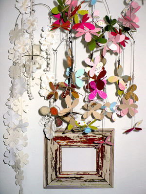 Dettaglio di un angolo del living con cornice shabby e ghirlande sospese
